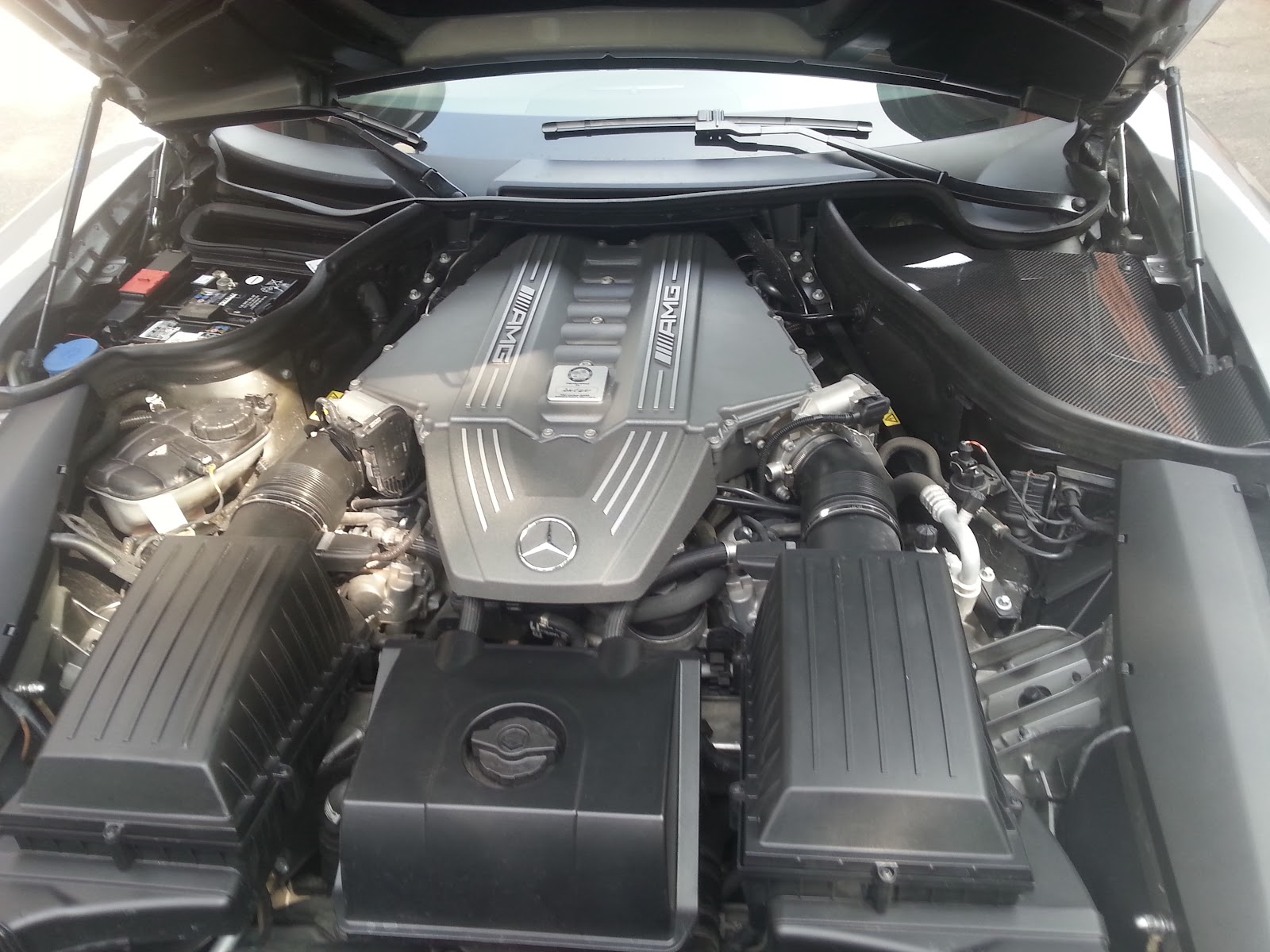 Geöffneter Motorraum eines Mercedes-AMG bei der Wartung